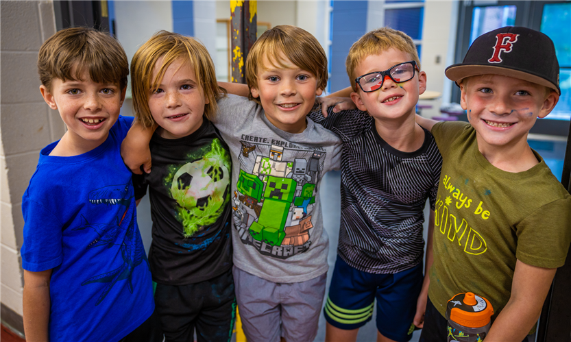 A group of five boys smiles